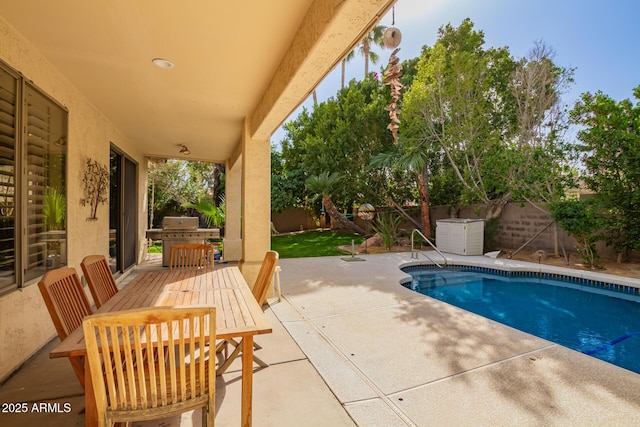 view of swimming pool featuring a patio, grilling area, a fenced backyard, and a fenced in pool