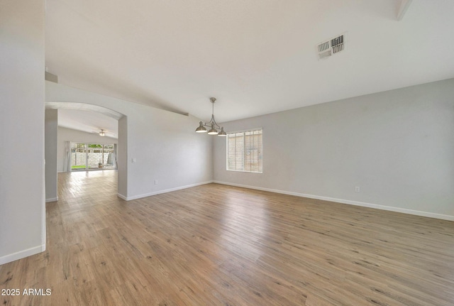 166 W Merrill Ct, Gilbert, AZ 85233 - empty room with a chandelier, light wood-style floors, arched walkways, and lofted ceiling