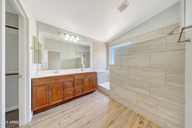 166 W Merrill Ct, Gilbert, AZ 85233 - bathroom featuring vaulted ceiling, double vanity, walk in shower, wood finished floors, and a chandelier