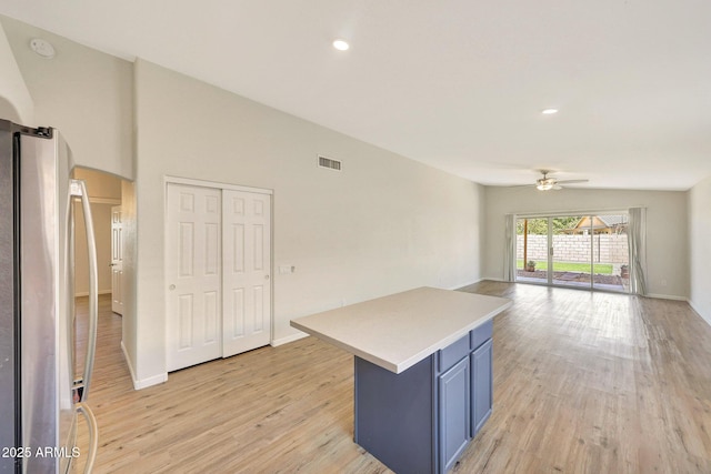 166 W Merrill Ct, Gilbert, AZ 85233 - kitchen with freestanding refrigerator, a ceiling fan, arched walkways, blue cabinetry, and light wood-style flooring