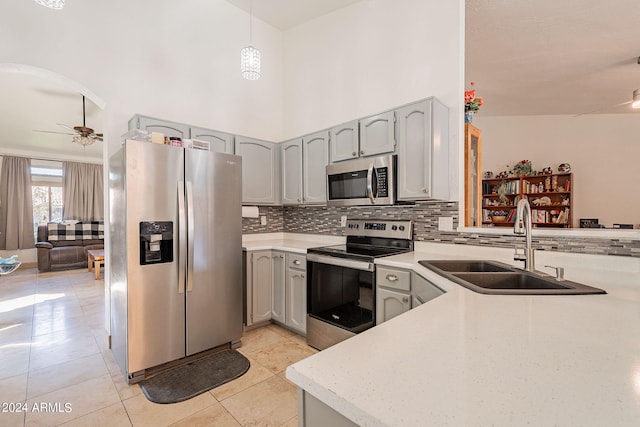 kitchen featuring pendant lighting, light tile patterned flooring, sink, stainless steel appliances, and ceiling fan