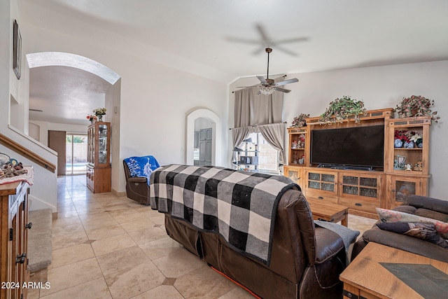 tiled living room featuring ceiling fan and lofted ceiling