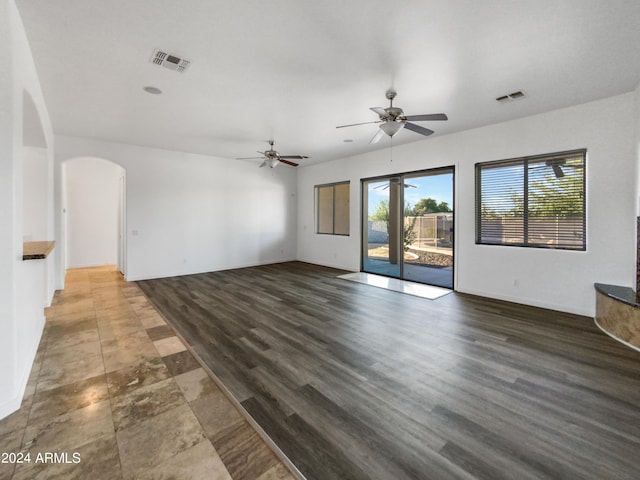 unfurnished living room featuring ceiling fan and dark hardwood / wood-style flooring