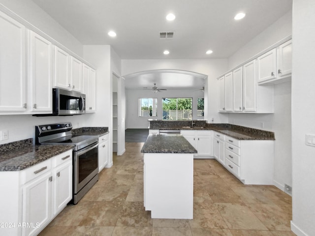 kitchen featuring ceiling fan, a center island, white cabinets, and appliances with stainless steel finishes