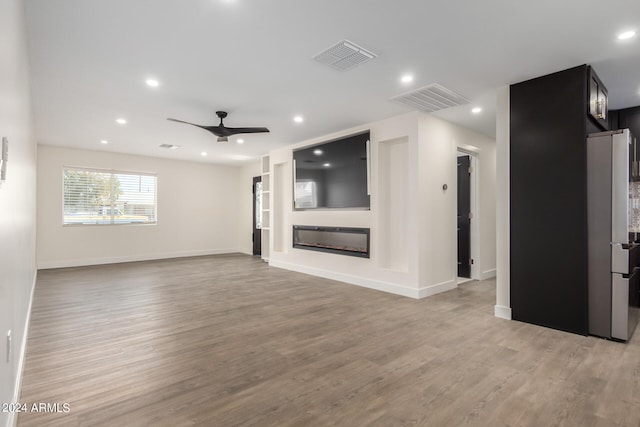 unfurnished living room with ceiling fan and light hardwood / wood-style flooring