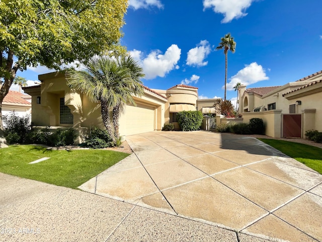 mediterranean / spanish-style home featuring a garage and a front yard