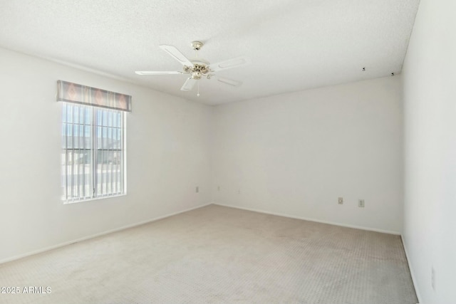 carpeted spare room featuring ceiling fan and a textured ceiling