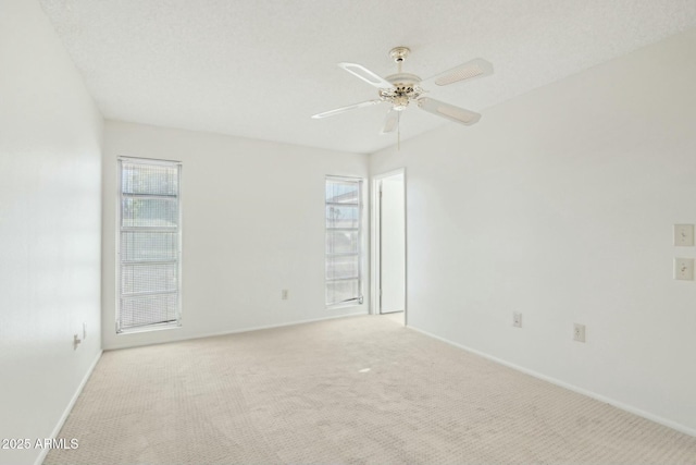 carpeted empty room with a wealth of natural light, ceiling fan, and a textured ceiling