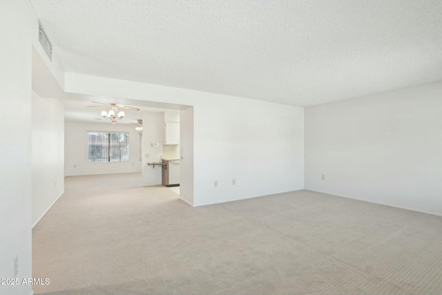 carpeted empty room with ceiling fan and a textured ceiling