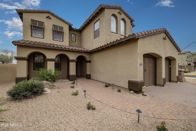 mediterranean / spanish home with stucco siding and a tiled roof