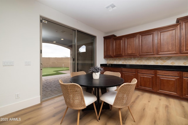 dining room featuring light wood-style floors and visible vents