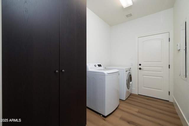 laundry room featuring visible vents, light wood-style flooring, washing machine and dryer, baseboards, and laundry area