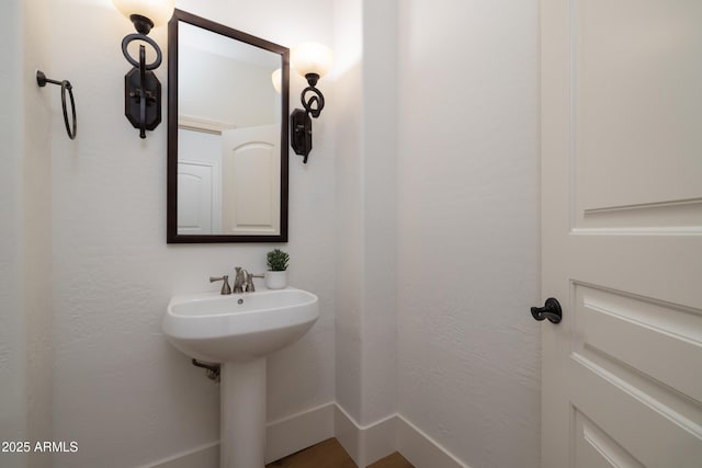 bathroom with baseboards and a sink