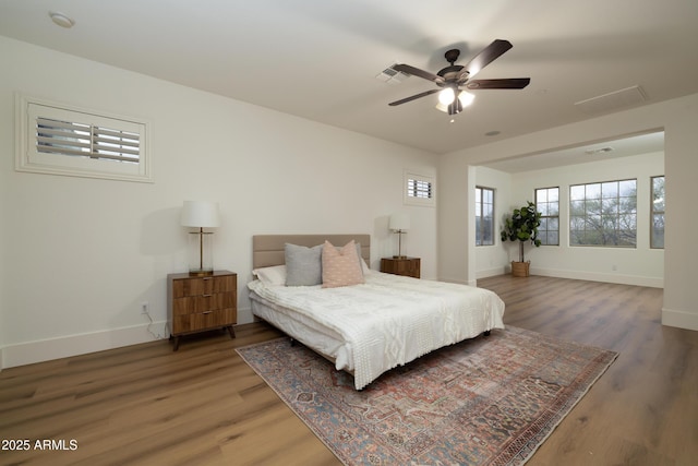 bedroom featuring ceiling fan, baseboards, and wood finished floors