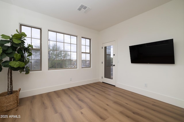 entrance foyer with wood finished floors, visible vents, and baseboards