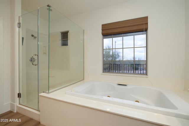 full bath featuring a jetted tub and a shower stall