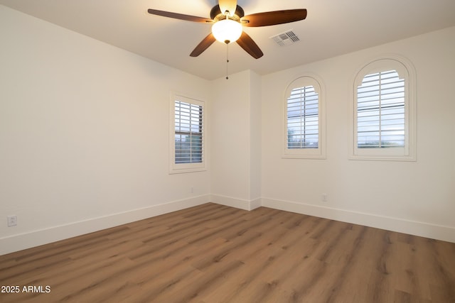 unfurnished room with ceiling fan, visible vents, baseboards, and light wood-style flooring