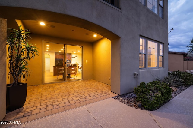 entrance to property with a patio and stucco siding