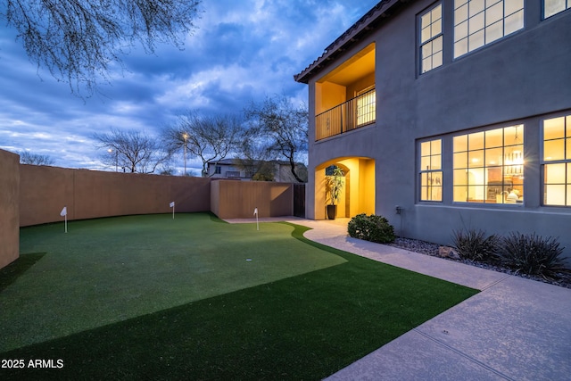 view of yard with a balcony and fence