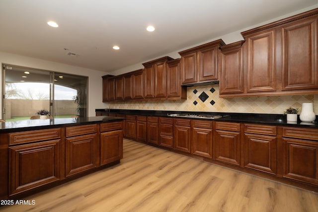 kitchen with dark countertops, visible vents, gas stovetop, and light wood-type flooring