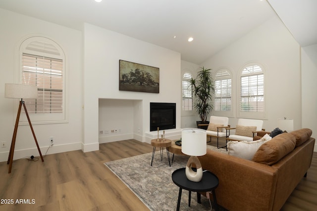 living room featuring recessed lighting, baseboards, lofted ceiling, and wood finished floors