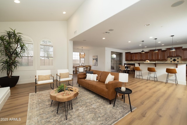 living room featuring light wood finished floors, visible vents, and recessed lighting