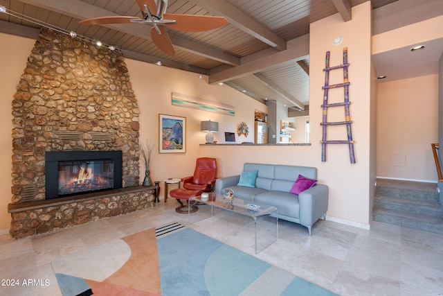 living room with ceiling fan, beamed ceiling, a fireplace, and wood ceiling