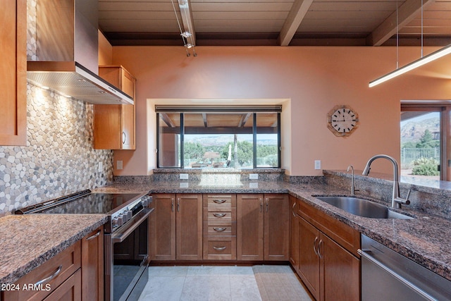 kitchen featuring beamed ceiling, sink, wall chimney range hood, appliances with stainless steel finishes, and dark stone counters