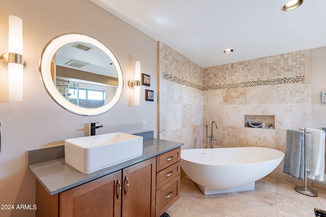 bathroom with a bathtub, tile walls, tile patterned flooring, and vanity