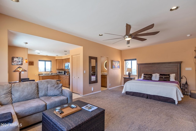 carpeted bedroom with ceiling fan and sink