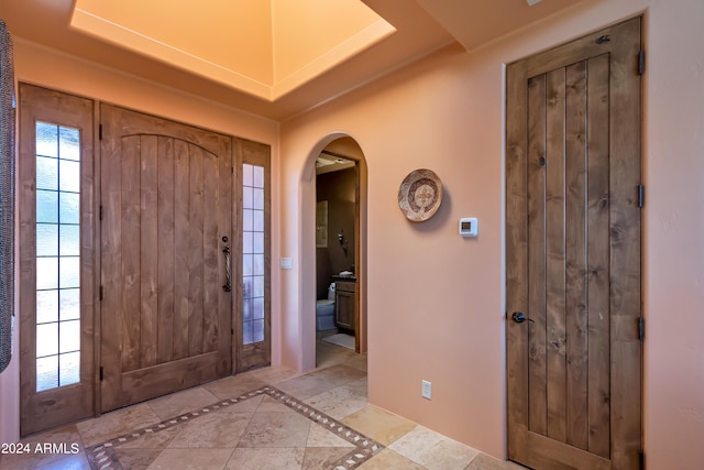 foyer entrance with a raised ceiling