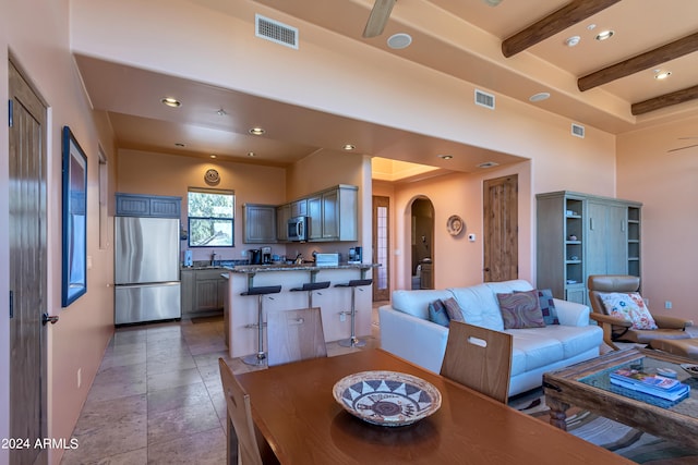 dining room featuring ceiling fan and beam ceiling