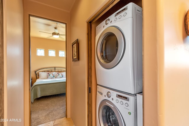 laundry room featuring ceiling fan, light colored carpet, and stacked washing maching and dryer