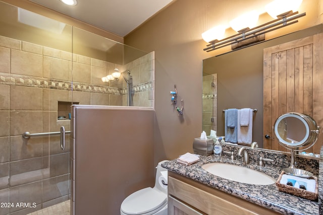 bathroom with vanity, a shower with shower door, and toilet