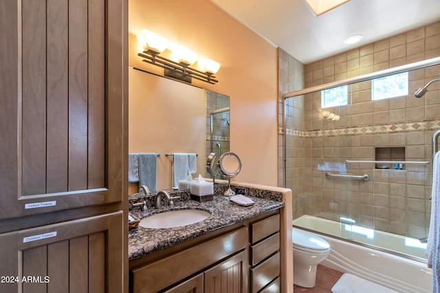 full bathroom featuring shower / bath combination with glass door, tile patterned flooring, vanity, and toilet