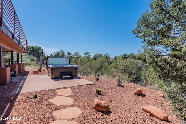 view of yard featuring a balcony, a hot tub, and a patio area