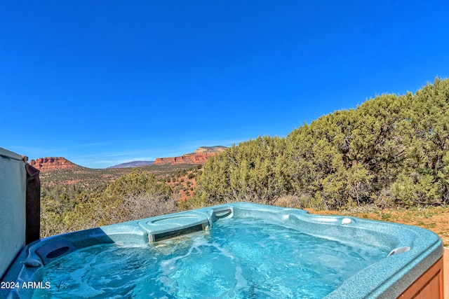 exterior space featuring a mountain view and a hot tub