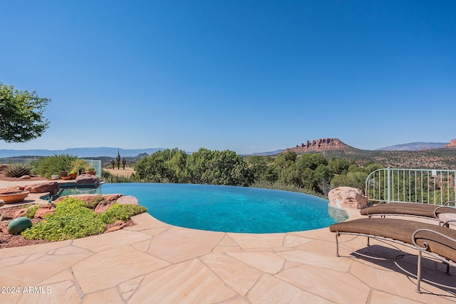 view of pool featuring a patio and a mountain view