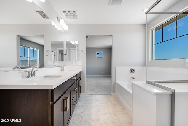 12219 W Caraveo Pl, Peoria, AZ 85383 - bathroom featuring a bath, double vanity, and baseboards