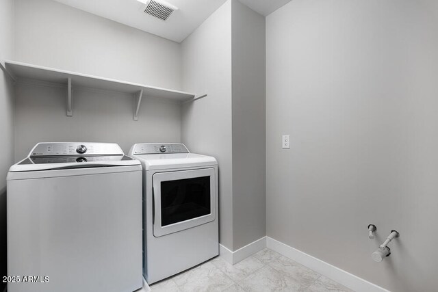 12219 W Caraveo Pl, Peoria, AZ 85383 - laundry room with washer and clothes dryer, light marble finish flooring, and baseboards