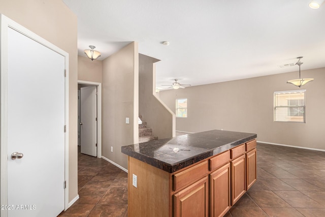 kitchen with visible vents, a ceiling fan, baseboards, tile counters, and decorative light fixtures