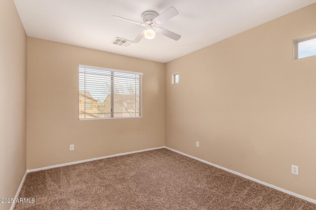 empty room featuring carpet, visible vents, ceiling fan, and baseboards