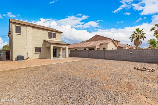 rear view of house featuring central air condition unit, a patio area, a fenced backyard, and stucco siding