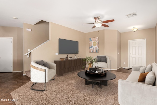 tiled living area featuring a ceiling fan, visible vents, and baseboards