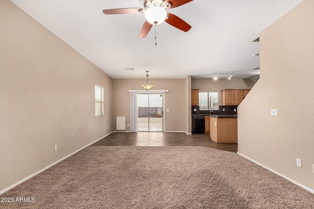 unfurnished living room featuring carpet floors, visible vents, a ceiling fan, tile patterned flooring, and baseboards