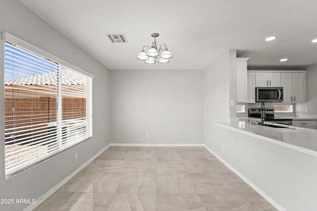 11215 W Heatherbrae Dr, Phoenix, AZ 85037 - unfurnished dining area with a chandelier, recessed lighting, baseboards, and a sink