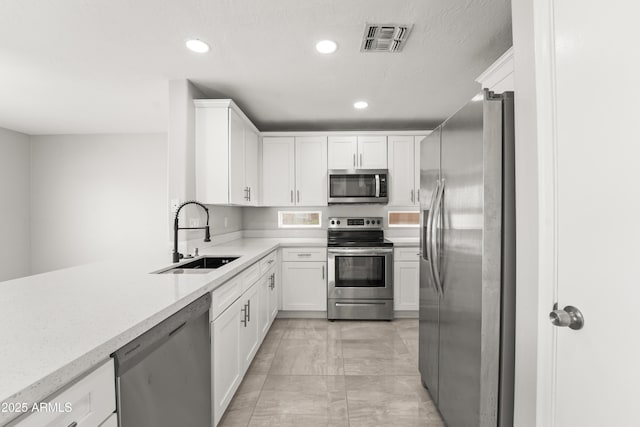 11215 W Heatherbrae Dr, Phoenix, AZ 85037 - kitchen featuring appliances with stainless steel finishes, a sink, light marble finish floors, recessed lighting, and white cabinetry
