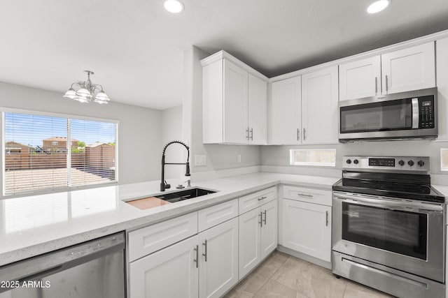 11215 W Heatherbrae Dr, Phoenix, AZ 85037 - kitchen featuring appliances with stainless steel finishes, a sink, a chandelier, white cabinetry, and recessed lighting