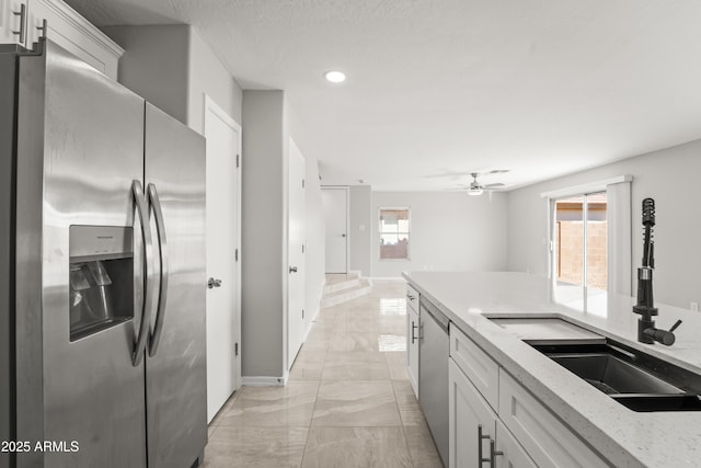 11215 W Heatherbrae Dr, Phoenix, AZ 85037 - kitchen featuring stainless steel appliances, light marble finish floors, a sink, ceiling fan, and baseboards