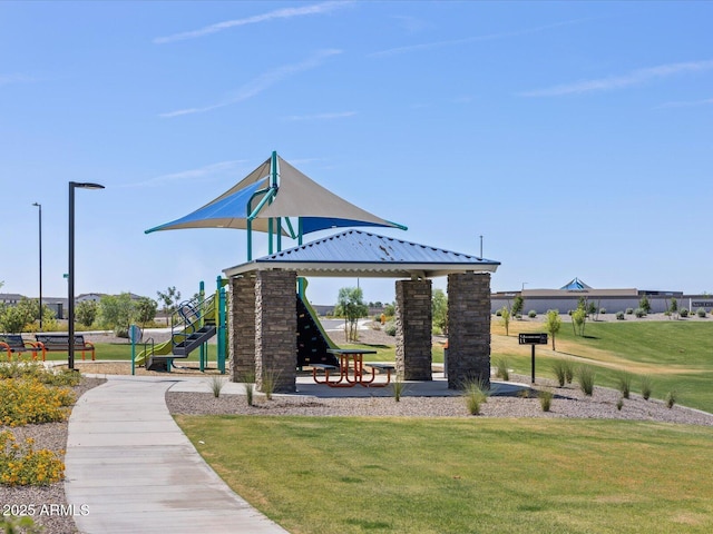 view of home's community featuring playground community and a yard